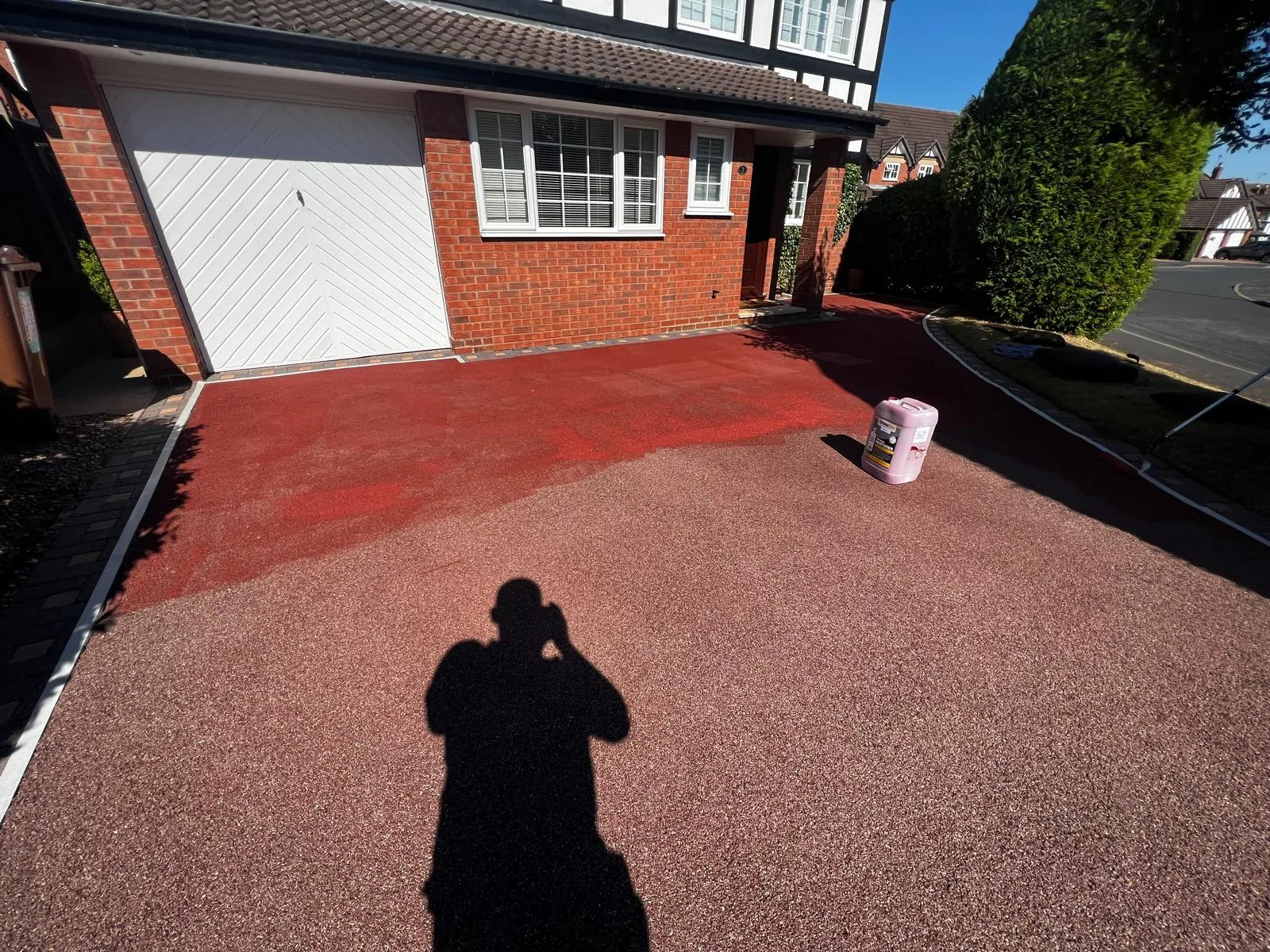Red resin driveway mid-treatment showing colour contrast